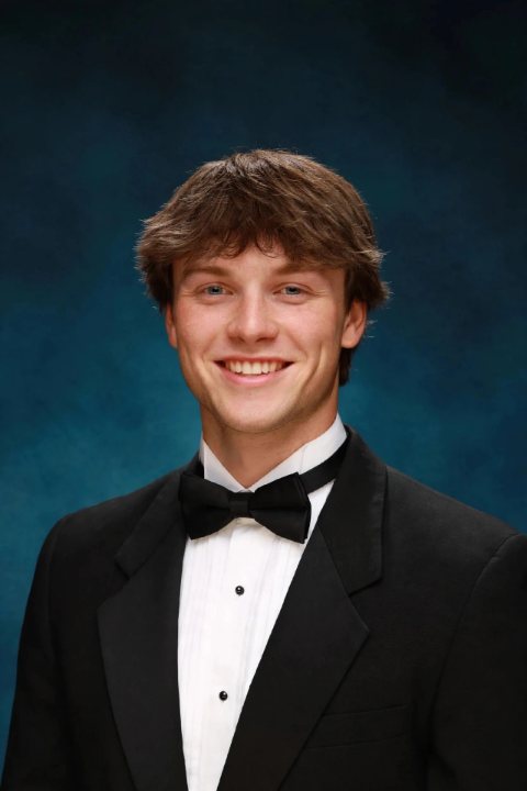A young man in a tuxedo, smiling